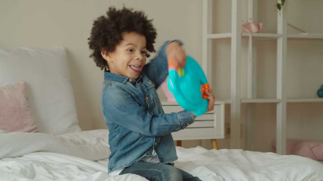 Boy laughing while playing on his bed